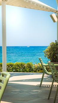 Home Relaxing seaside terrace view with azure ocean and clear skies, ideal for summer getaways.